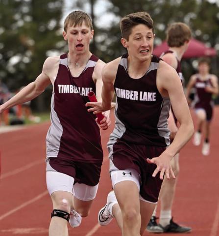 Timber Lake’s Holden Gill (left) passes the baton to teammate Landen Bieber during a relay race at the Timber Lake Track Invitational last Thursday, May 1, at Doug Kraft Field. Photo by Marie DuPreez