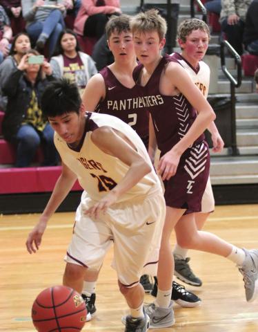 Panthers Cole Ducheneaux (L) and Kyler Bollinger (R) watch McIntosh’s Ashton High Cat chase a loose ball during their recent high school basketball contest. Photo by Jon Flatland