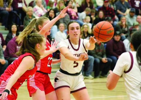 Timber Lake senior McKenzi Vomacka fires a pass to a teammate while being pressured by a pair of Potter County defenders during girls basketball action last Friday. The Lady Panthers won three games last week to improve to 6-3 overall. Photo by Jon Flatland