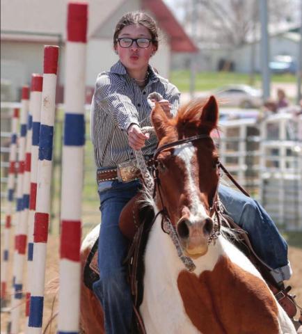McKenzie Longbrake of Dupree weaves trhough the poles on her horse. Photo by Jon Flatland