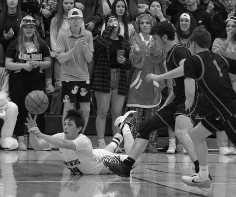 Timber Lake junior forward Rance Martin (34, on floor) pushes a pass to a teammate as he falls to the court after being tripped while playing low point in the Panthers quarterfinal win over Faith last Tuesday, March 4.