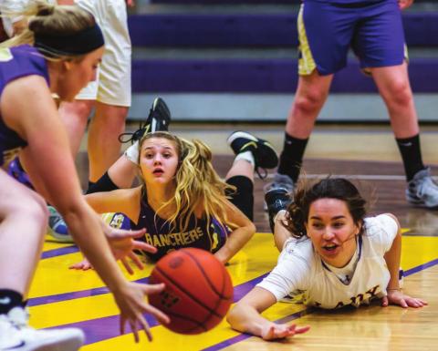 Harding County’s Bailey Verhulst (LEFT) scoops up the basketball after Dupree’s RaeLynn Vines (RIGHT) dove to keep it away from Rancher Reese Hunsucker (CENTER) during the Little Moreau Conference game.