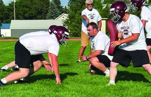 Dan Porisch (kneeling right), starting center for the Northern State University Wolves, runs players through drills at a football camp hosted by two local NSU players - Hank Kraft of Timber Lake and Brady Bauer of Mobridge-Pollock.