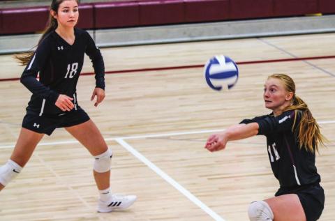 Jordan Jones prepares to return a serve while teammate Natalie Gross watches during recent volleyball action. File photo by Jon Flatland