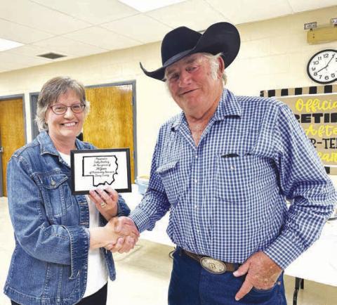 Cathy Lemburg received a plaque from Dewey County Commission Chairman Bob Berndt at a retirement party in her honor on June 19. She also received a star quilt from county employees presented by Highway Supt. Will Wiedmer.
