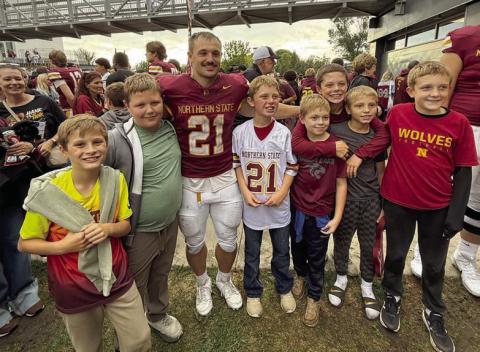Vern Long (in white jersey) celebrated his tenth birthday at a packed-house Gypsy Days game at NSU in Aberdeen on September 26. The highlight of the day for Vern and his friends was getting to see Hank Kraft (in maroon jersey) after the game and have his #21 jersey autographed. “Hank the Tank” made two touchdowns as the NSU Wolves defeated University of Mary 24-17. L-R are Jackson Quaschnick, Hank Anderson, Vern Long, Ryder Spiel, Landon McComsey, Barrett Hermes, and Oliver McComsey.