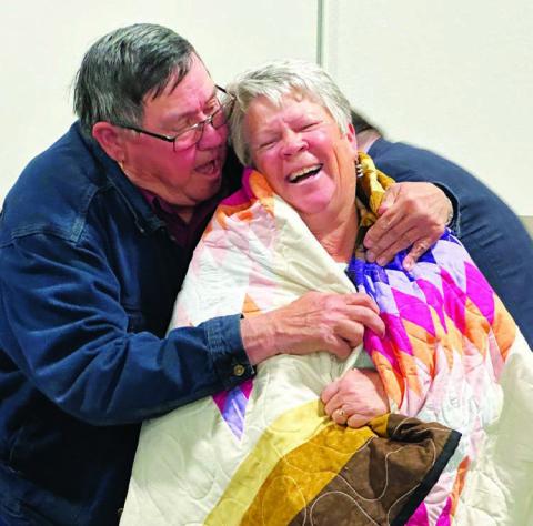 Board member Paul Lawrence presents out-going MGEC Manager Melissa Maher with a star quilt during the cooperative’s 78th annual meeting last Wednesday, Oct. 9. Photo by Kathy Nelson
