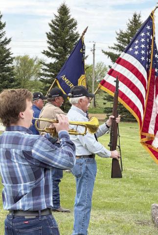 Caleb Quinn played TAPS at the Timber Lake Cemetery as part of the Memorial Day program on May 26. Veterans who fired a salute over teh grave of Patrick Quinn are (l-r) Ken Quinn (Legion Post 83 Commander), Roger Hieb, and Jack Bickel. Photo by Kathy Nelson