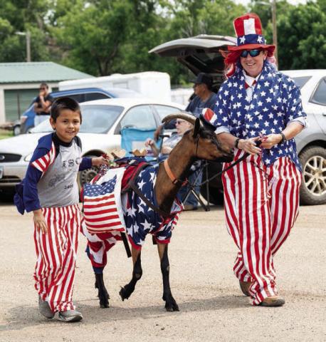 Ares Carlson and Casey Keckler with a goat appropriately dressed for the occasion.