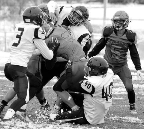Panther defenders Chazz Gabe (3) Patrick Marshall (77) and Jaiden Ducheneaux (40) gang up on a Philip ball carrier during their 9-man playoff football game last week. Photo by Chelsea Tobin, Philip Pioneer Review