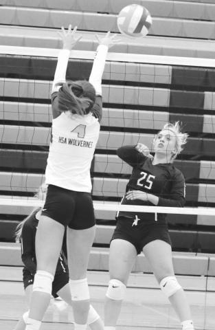 Sophomore outside hitter McKenzi Vomacka (25) puts a shot over the outstretched hands of an unidentified Herreid-Selby defender (4) during recent action. Photo by Jon Flatland