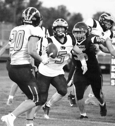 Herreid-Selby QB Tray Hettick (5) looks to dish the ball to running back Brenden Begeman (20) while being pressured by Timber Lake lineman AJ Lindskov (55) during the Panthers home opener last Friday. Photo by Jon Flatland