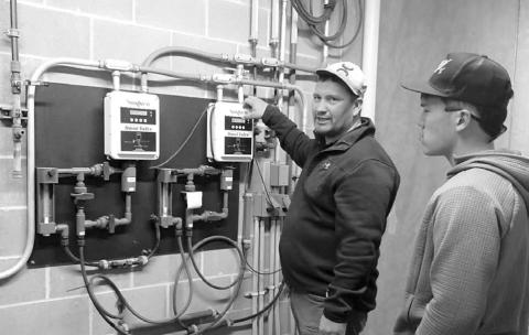 ABOVE: Danny Marshall of Mni Waste Water Company, teaching the students about the pipe process and Tre White Wolf, a DHS senior.