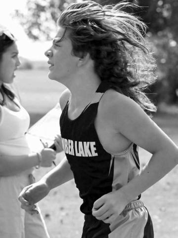 The signature long locks of Timber Lake seventh grader Mason Kraft (right) were blowing in the breeze last Thursday at the C-EB Cross Country Invitational. Kraft, competing in his first varsity race, posted a time of 22:19.00 to land 17th overall. Photo by Jon Flatland