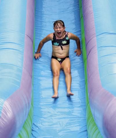 Clara Nilson, daughter of Kyle and Alision Nilson, screams as she goes down the giant water slide at the Timber Lake Fire Department’s annual 4th of July picnic last Friday. The water slide and other inflatables helped the kids beat the heat outside while the firemen served up traditional picnic food of burgers, hot dogs and watermelon in the Timber Lake Community Center. Photo by Jon Flatland