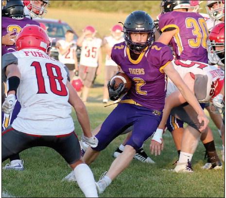 A wide-eyed Cruz Birkeland (2) puts a move on a Potter County defender during the Dupree Tigers 56-6 win over the Battlers at Tiger Field last Friday, Sept. 13. Birkeland, a junior running back and linebacker, had a career day, scoring five rushing touchdowns and a defensive TD when he scooped up a blocked Potter County punt and took it into the end zone. Photo by Jon Flatland