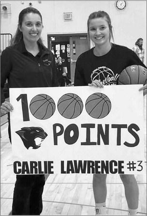 Timber Lake Coach Erin Gimbel (left) last Tuesday, Dec. 6, welcomed senior Carlie Lawrence into the 1,000 Career Point Club during the Lady Panthers girls basketball home opener against Tiospaye Topa. The daughter of Cody and Mary Lawrence, she actually reached the milestone in the final game of last season during the Region 8B Tournament but school officials waited to recognize the achievement in front of a hometown crowd to open this season. Courtesy Photo