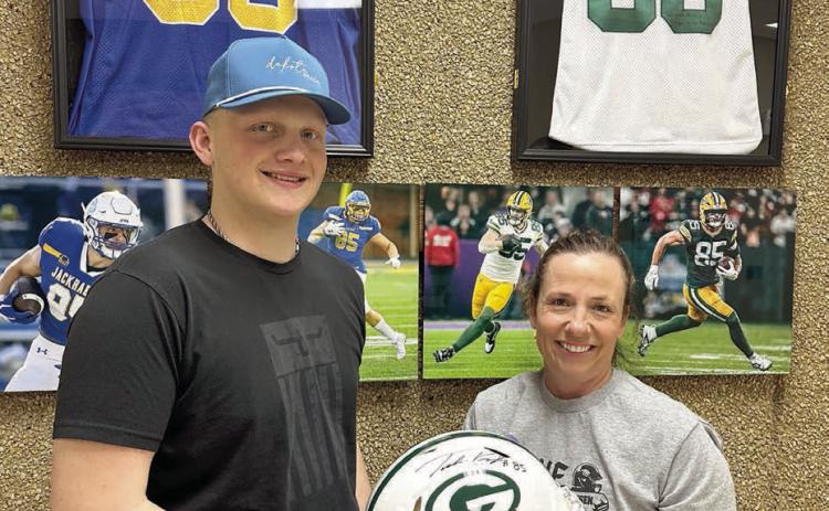 Mae Keller (RIGHT) took home the Green Bay Packers helmet autographed by Tucker Kraft with a bid of $20,000 at the benefit for Braylen Hansen (left), a senior at Timber Lake High School, held March 13. (More inside) Photo by Kathy Nelson