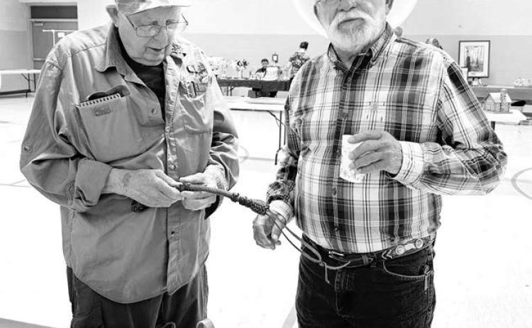 Sea of Grass artists James Pollock (left) of Pierre and Mick Harrison of Belle Fourche check out some leather work by Don and Unalee Howe of Dupree (pictured below). Unalee was director of the Sea of Grass art project in 2015.