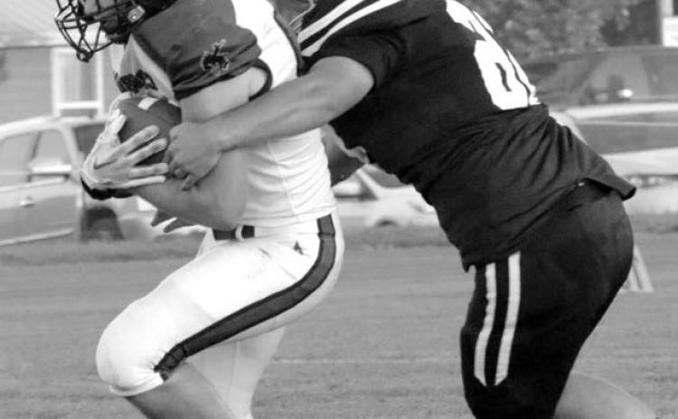 Senior lineman Dan Peterson wraps up a Lemmon-McIntosh runner during his return to the field last Friday after missing all of last season with an injury and immediately made his impact felt on both sides of the ball, protecting quarterback Gracen Hansen on offense and collecting four tackles and three assists, including two stops for lost yardage, on defense. Photo by Jon Flatland
