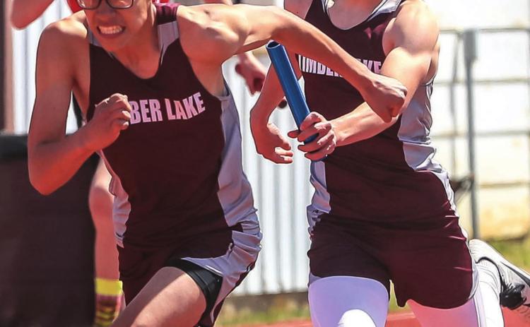 Otto Red Bear has determination on his face as he takes the handoff from Gracen Hansen during their 4x200 relay race at last week’s last chance meet.