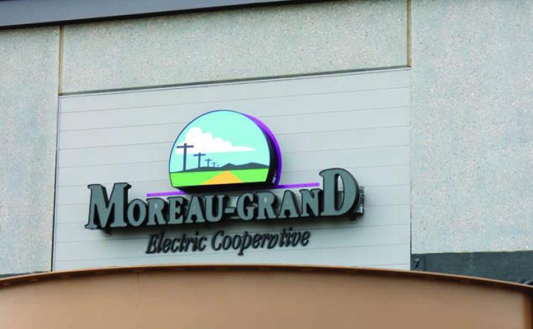 An electrical technician works atop the roof of the new Moreau-Grand Electric Cooperative building last week while wiring the sign above the main entrance. The sign looks most impressive when lit at night. Photo by Jon Flatland