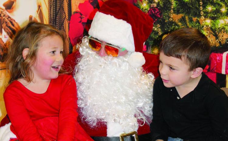 Olive Anderson and Kaysen Smith eagerly shared their Christmas wish lists with Santa Claus during his visit to Dupree for the community’s annual Parade of Lights celebration on Dec. 6. Topic photo by Patty Peacock
