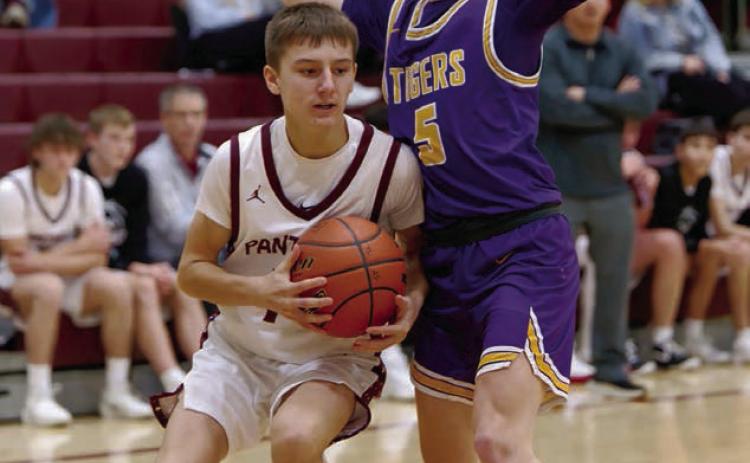 Panther guard Kruz Lindskov gets bumped by a New Underwood defender as he works his way along the baseline . Find more boys and girls basketball coverage on Pages 8 and 9. Topic Photo/Marie DuPreez