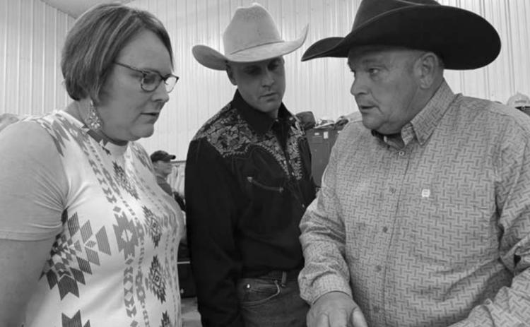 Laurie Bickel, Levi Goldade and John Hoven check the list of items for the live auction.