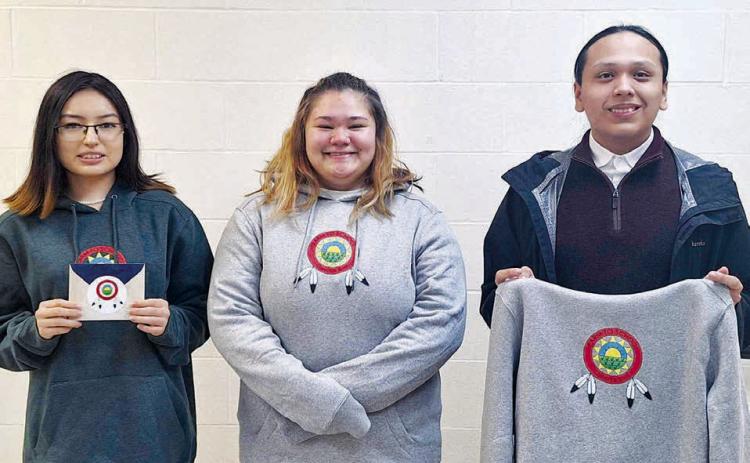 Dupree students who participated in the CRST Farm to School logo contest included (l-r): Jamie Black Moon (who won second place), Izzy Jeffries, and Wambli Quintana. They are displaying the winning logo, which was created by Alicia Condon, a student at Takini School. Photo by Patty Peacock