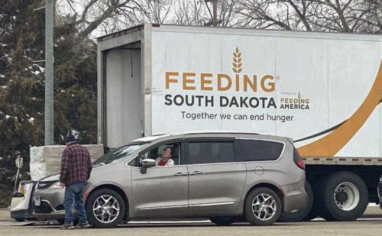 A Feeding South Dakota volunteer interacts with a food recipient at the organization’s March food distribution on Main Street of Isabel. Photo by Jon Flatland