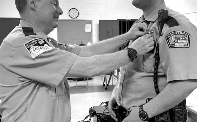 Retiring Corson County Sheriff Keith Gall (LEFT) pins the sheriff’s badge on his former deputy, Alan Dale, who was appointed sheriff effective March 13.