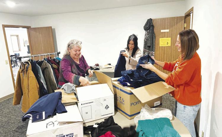 A community drive to make winter coats, jackets, gloves, boots, and other cold-weather clothing available to those who need it got off to a start last week. Here (l-r) Lilian Turcotte, Becky Booth and Kasey Maher sort donations to be displayed. Anyone is welcome to take what they need or drop off new or gently used items of all sizes at The Junction. The room behind the Grounded Coffee Shop will be open Tuesdays through Fridays from 9 a.m. to 4 p.m. until further notice. Photo by Kathy Nelson