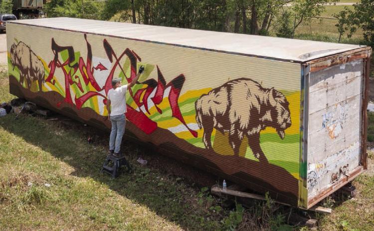An artist works on a mural in Eagle Butte during the 2022 RedCan Graffiti Jam. The 9th annual event got underway Wednesday and continues through Saturday. (Photo by CRYP)