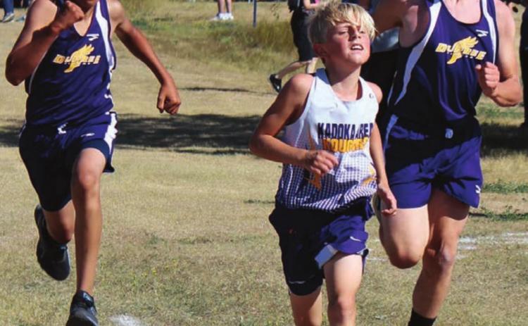 ABOVE LEFT: Dupree’s Tripp Schrempp (L) and Case DePoy converge on either side of a Kadoka runner as they approach the finish line in cross country action at the LMC meet Saturday. Photo by Patty Peacock