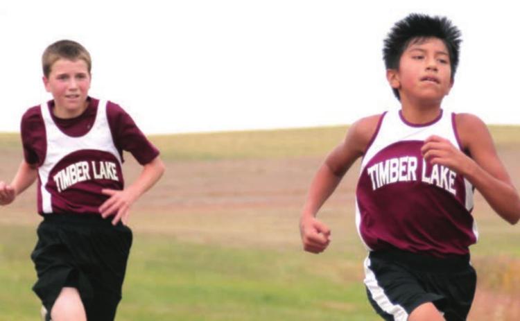 Demetrius Sanchez and Thomas Holzer race in their home cross country meet.
