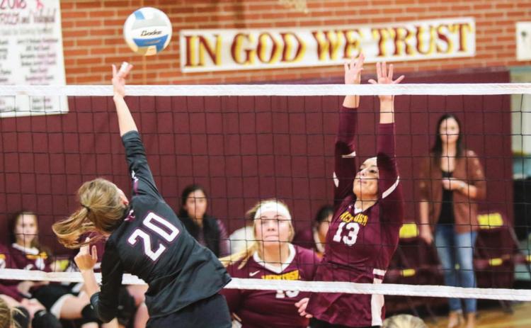 Timber Lake middle hitter Molly Kraft (20) powers a spike past the defense of Mcintosh's Meghan Maher (13) and Reyna Nehl (15) during varsity volleyball action on Oct. 1 in Mcintosh. Photos by Jon Flatland