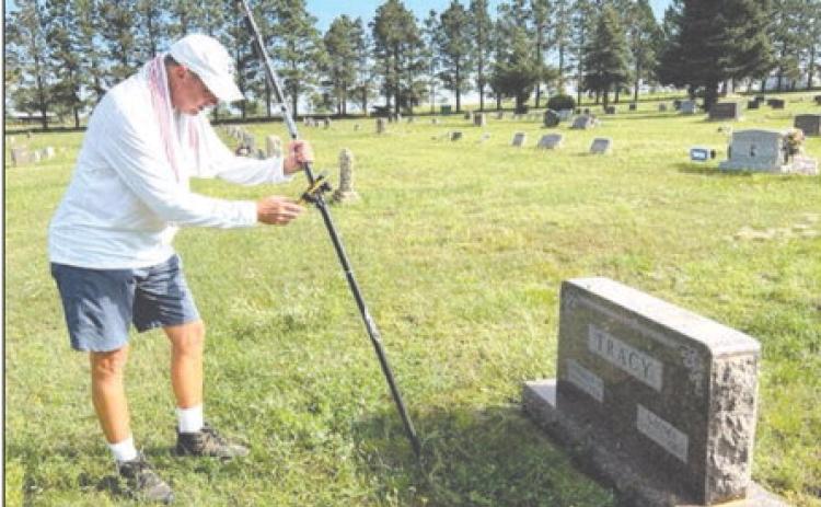 Benton Smith of Sentry Mapping Services in Oxford, MS, logs in GPS coordinates and photographs a headstone as part of a mapping project at the Timber Lake Cemetery. Photo by Jon Flatland