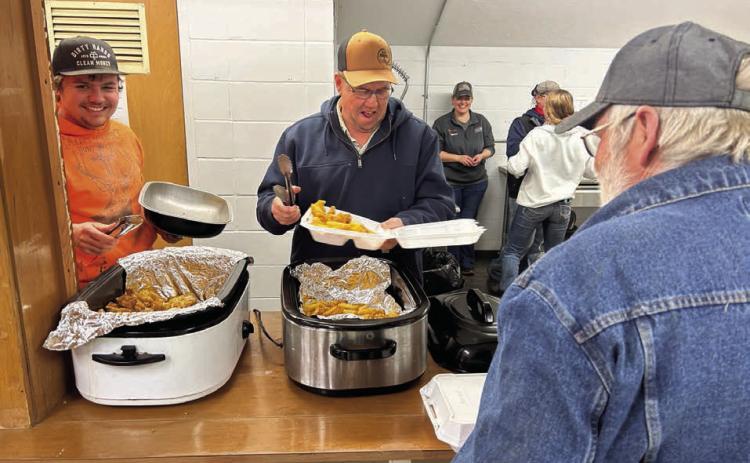 Tye Boldt (left) and Tucker Stocklin share a laugh while dishing up fish and French fries forTim Johnson at the annual Knights of Columbus fish fry at the Isabel Community Center last Friday, March 28.The K of C fish fry moves to Trail City this Friday, April 4, and will be held in Timber Lake on Friday, April 11. (See advertisement on Page 11) Photo by Jon Flatland