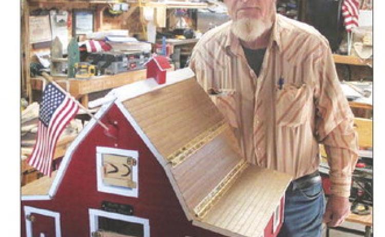 Dave Doan with one of his handcrafted barns. Photo by Jon Flatland