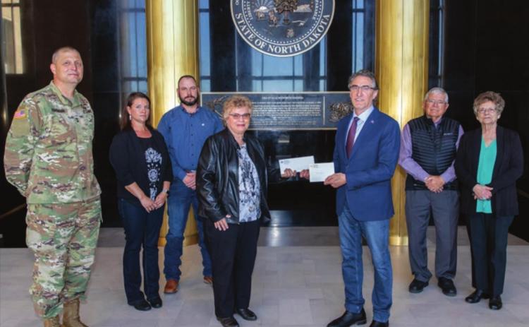 North Dakota Gov. Doug Burgum presents Ron Hepper’s military ID tag (dog tag) to his widow, Ruth Hepper of Bismarck and formerly of Isabel, on Wednesday, Sept. 30, at the North Dakota State Capitol in Bismarck. Also pictured are (L-R) Maj. General Al Dohrmann, Hepper’s daughter Julie Hornbacher and her husband, Jim, and Ron Hepper’s brother Stanley Hepper and his wife, Kathleen.