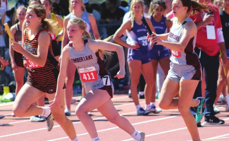ABOVE: Shay Kraft hands the baton to Averie Marshall in the girls 400 meter relay state finals, in which the team, including Maci Maher and Kiya Mowrer, broke the school record. Photo courtesy of SD Public Broadcasting