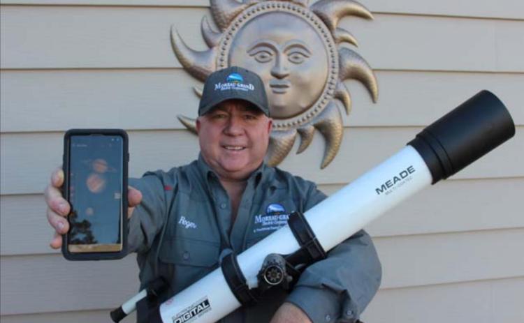 Amateur astronomer Roger Lawien shows off his telescope and the cellular telephone app he uses to help him find planets, stars and constellations. Photo by Jon Flatland
