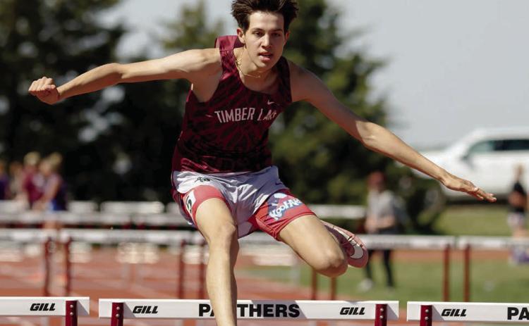 AT LEFT: Jackson Bigger clears a bar enroute to a first place finish in the 300 meter hurdles.  Photo by Marie DuPreez