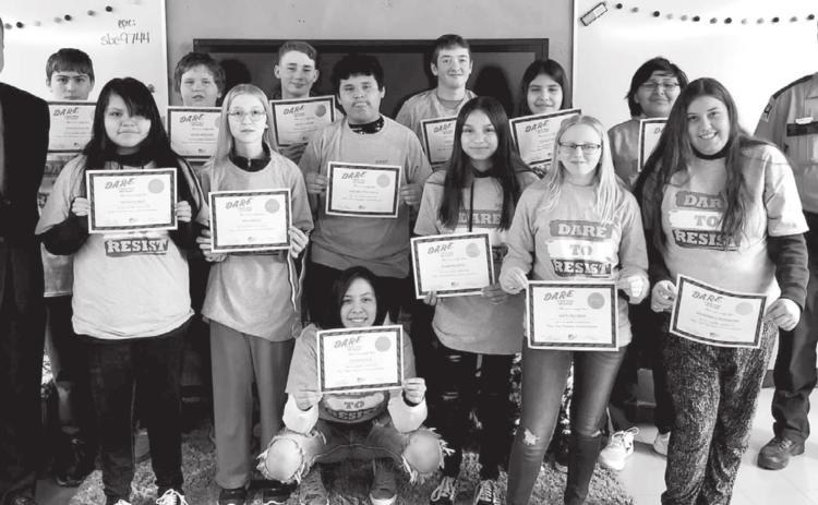 McIntosh DARE graduation. FRONT (L-R): Guest speaker Shane Penfield, Mileigh Eagle, Mia Hanson, Olivia Geigle, Jessmyn Hertel, Kaitlyn Lynch, Abundance Bjornstad; BACK: Dominick Klein, Adam Jaragoske, Wyatt Larson, Carmelo Little Eagle, Curtis Conner, Ozziah Ulmer, Corey Flying Bye, Corson Co. Sheriff Alan Dale.