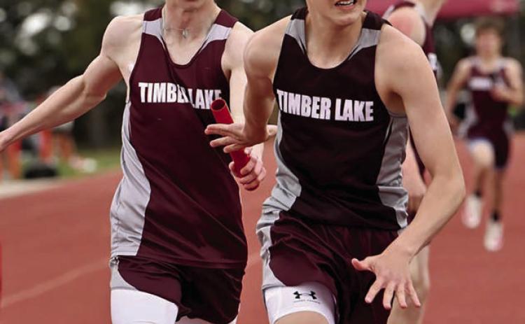 Timber Lake’s Holden Gill (left) passes the baton to teammate Landen Bieber during a relay race at the Timber Lake Track Invitational last Thursday, May 1, at Doug Kraft Field. Photo by Marie DuPreez