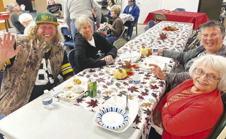 Nick Johnson (left) with a table of new-found friends at the Timber Lake Museum potluck dinner on Sunday (l-r) Johny Weber, Judy Garon and Patty Kjellsen.