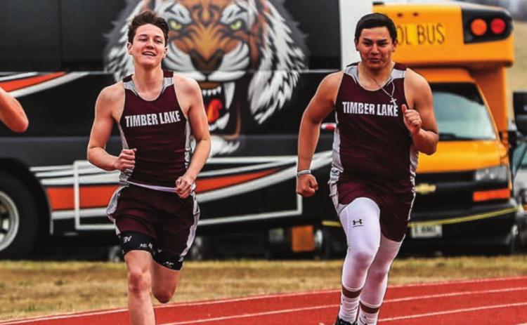 Timber Lake runners (L-R) Aidan Rough Surface, Tell Murray, Jaiden Ducheneaux and Ashton Kerstiens sprint toward the finish line in the 400m run. Photo by Robert Slocum