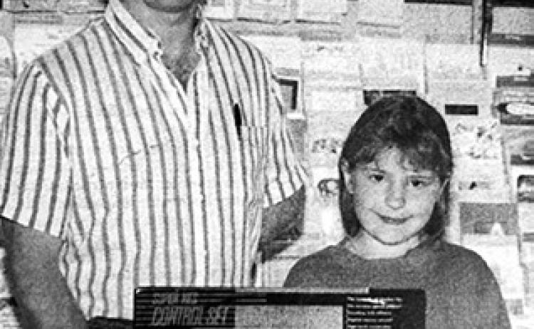 Samantha Reinbold, daughter of Robert and Jeanette Reinbold, was the winner of a Super Nintendo given away during the Kids’ Week promotion. Making the presentation is Dennis Holzer of Holzer’s Super Valu. Timber Lake Topic, June 17, 1993