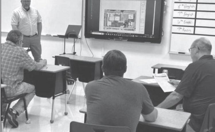 John Paul, standing, of Johnson Controls, fields questions from Timber Lake School officials last Wednesday, Aug. 23, while discussing a $1.8 million HVAC improvement project the board approved later in the evening. Photo by Jon Flatland